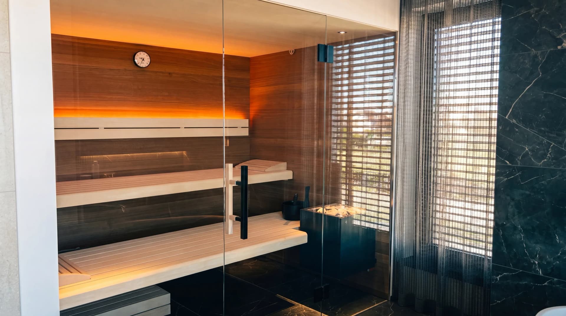 Maßgefertigte Indoor-Sauna aus Zirbenholz mit Glasfront und warmer LED-Ambientebeleuchtung – Premium Saunenbau aus Niederbayern